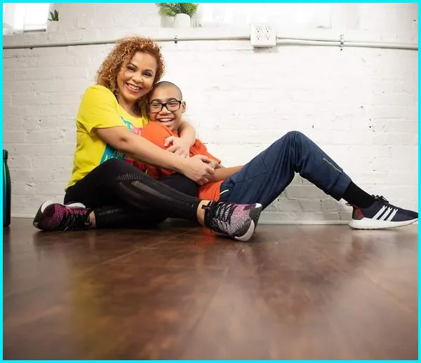 Yara N. Ortiz sitting on the floor with her son, both smiling
