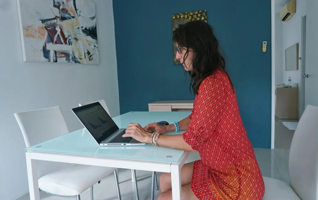 Woman working on a laptop at a table at home