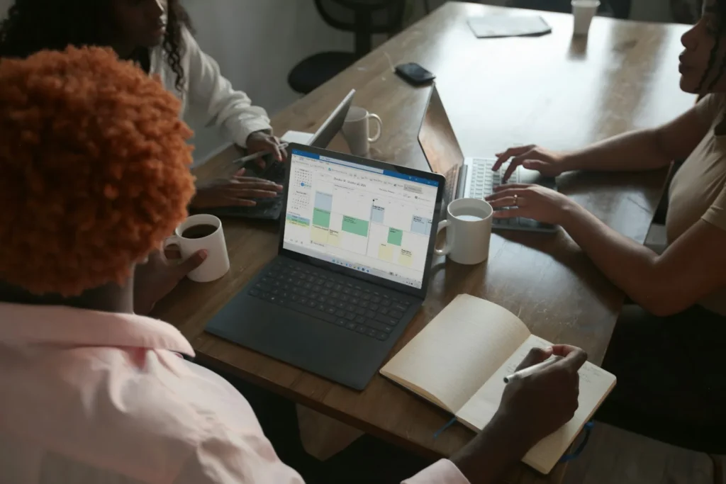 Three colleagues planning a schedule together at a laptop