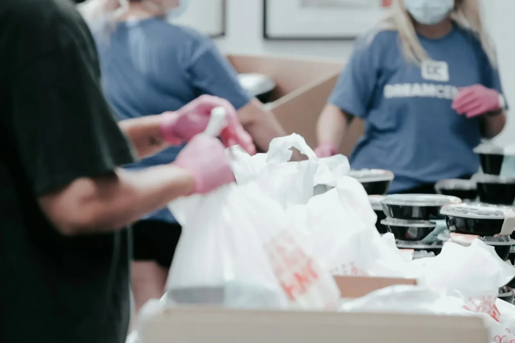 Volunteers in blue shirts packing food into bags